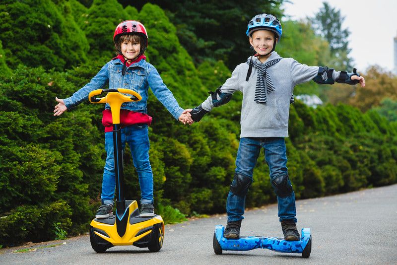 2 Kids riding electric hoverboards in the street